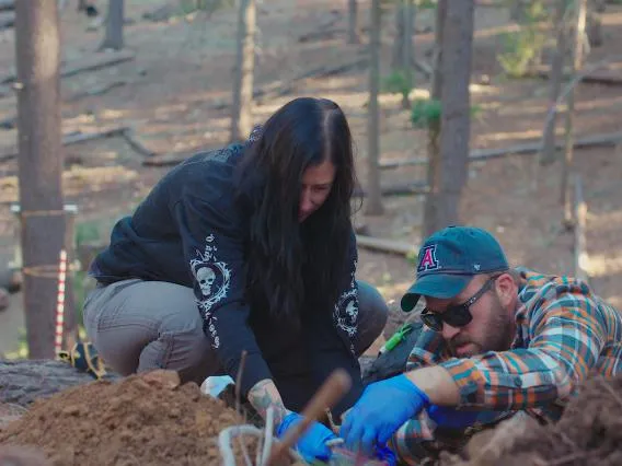 Two people digging in soil.